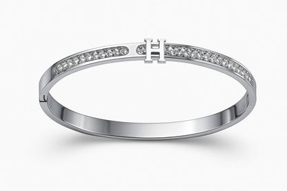 Elegant silver-colored bracelet with 'H' centerpiece on white background