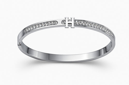 Elegant silver-colored bracelet with 'H' centerpiece on white background