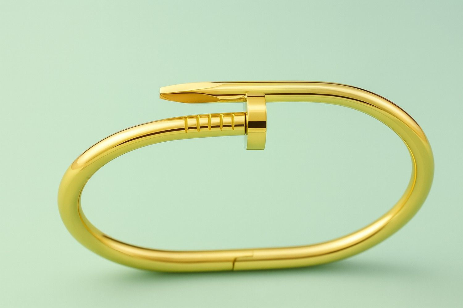 Gold-tone bracelet in nail-inspired design on green background