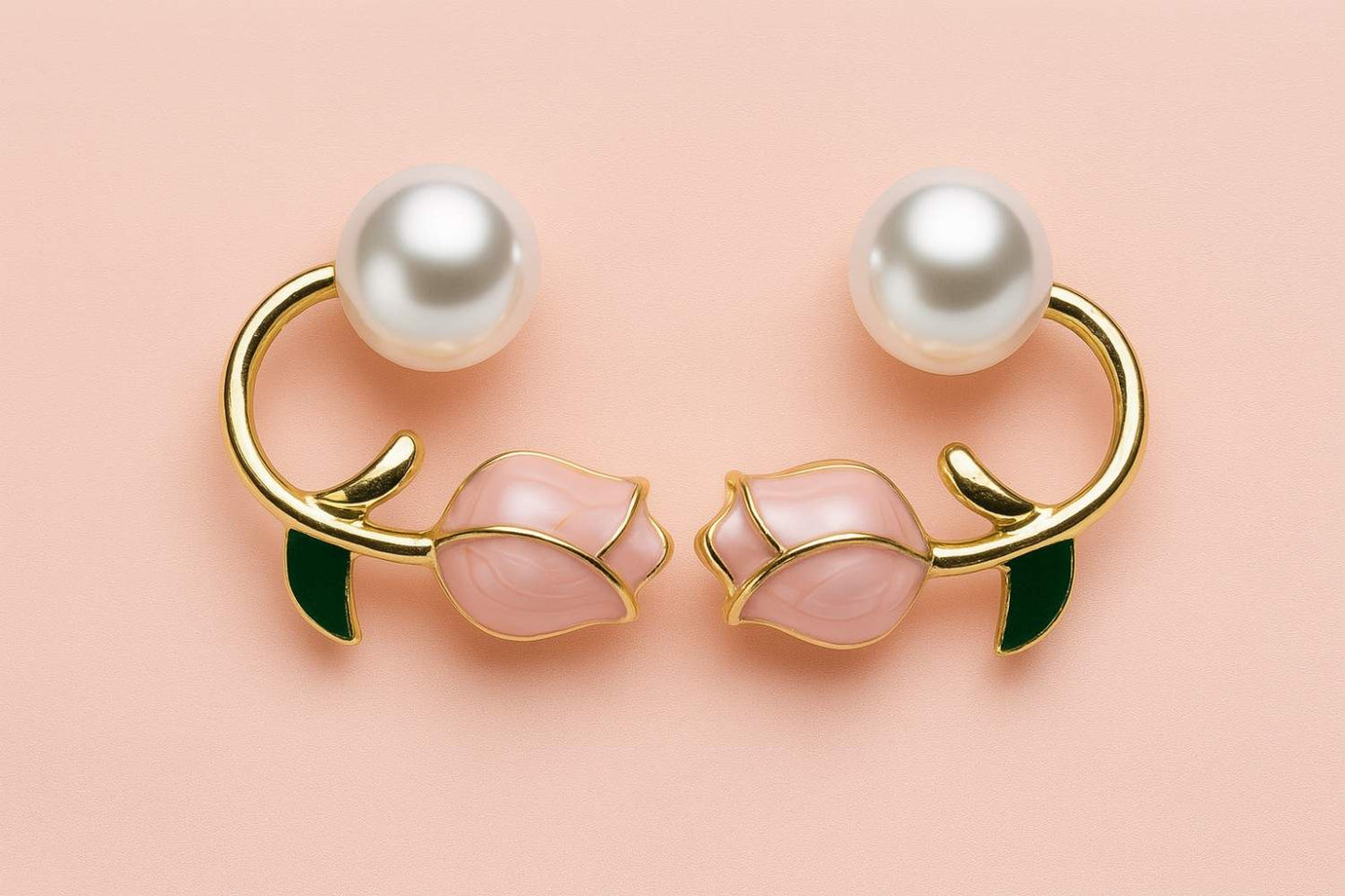 "Elegant gold-tone pearl and pink rose bud earrings with green enamel leaf detail on pastel background"