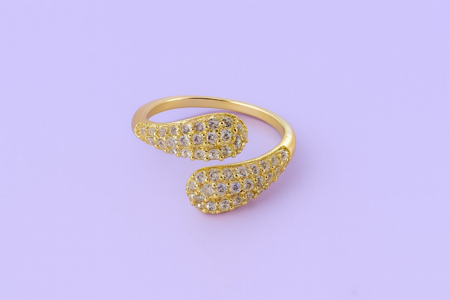 "Gold-tone teardrop crystal ring with twin ends and sparkling stones"