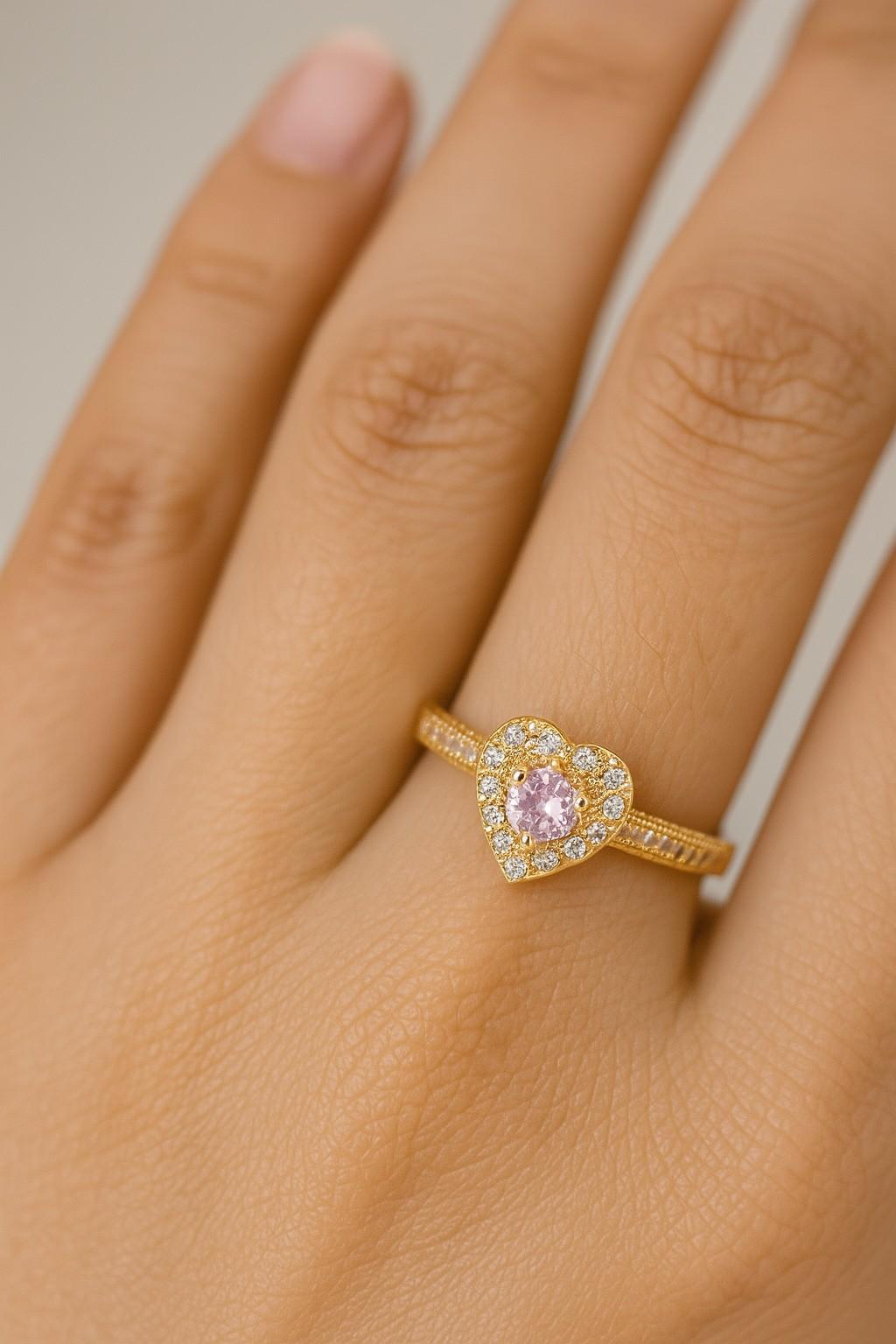 "Model wearing gold-tone pink heart crystal ring with adjustable fit"