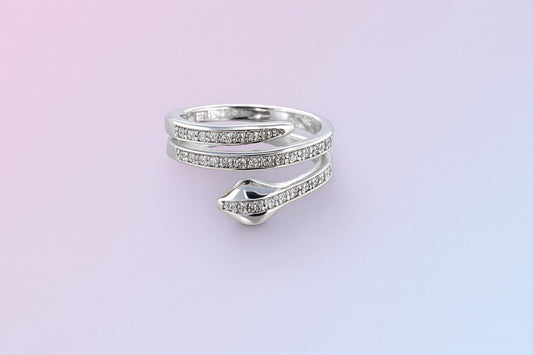 "Silver-tone snake wrap ring with crystal-studded design on pastel background"

