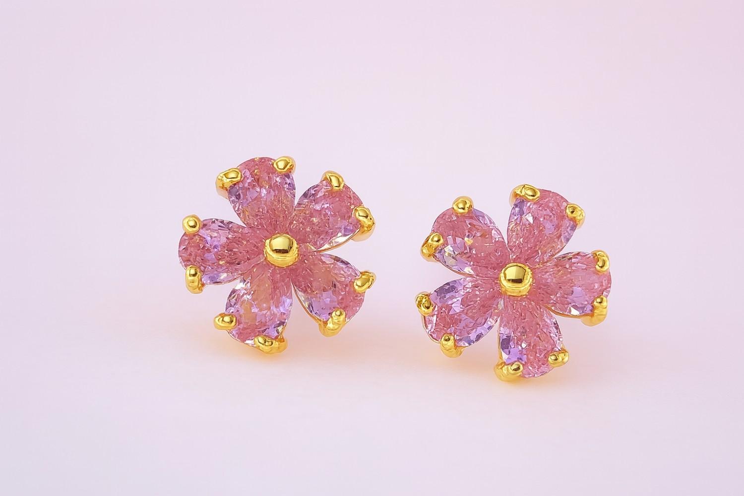 Pink floral stud earrings with gold-tone finish on white background