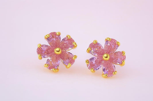 Pink floral stud earrings with gold-tone finish on white background