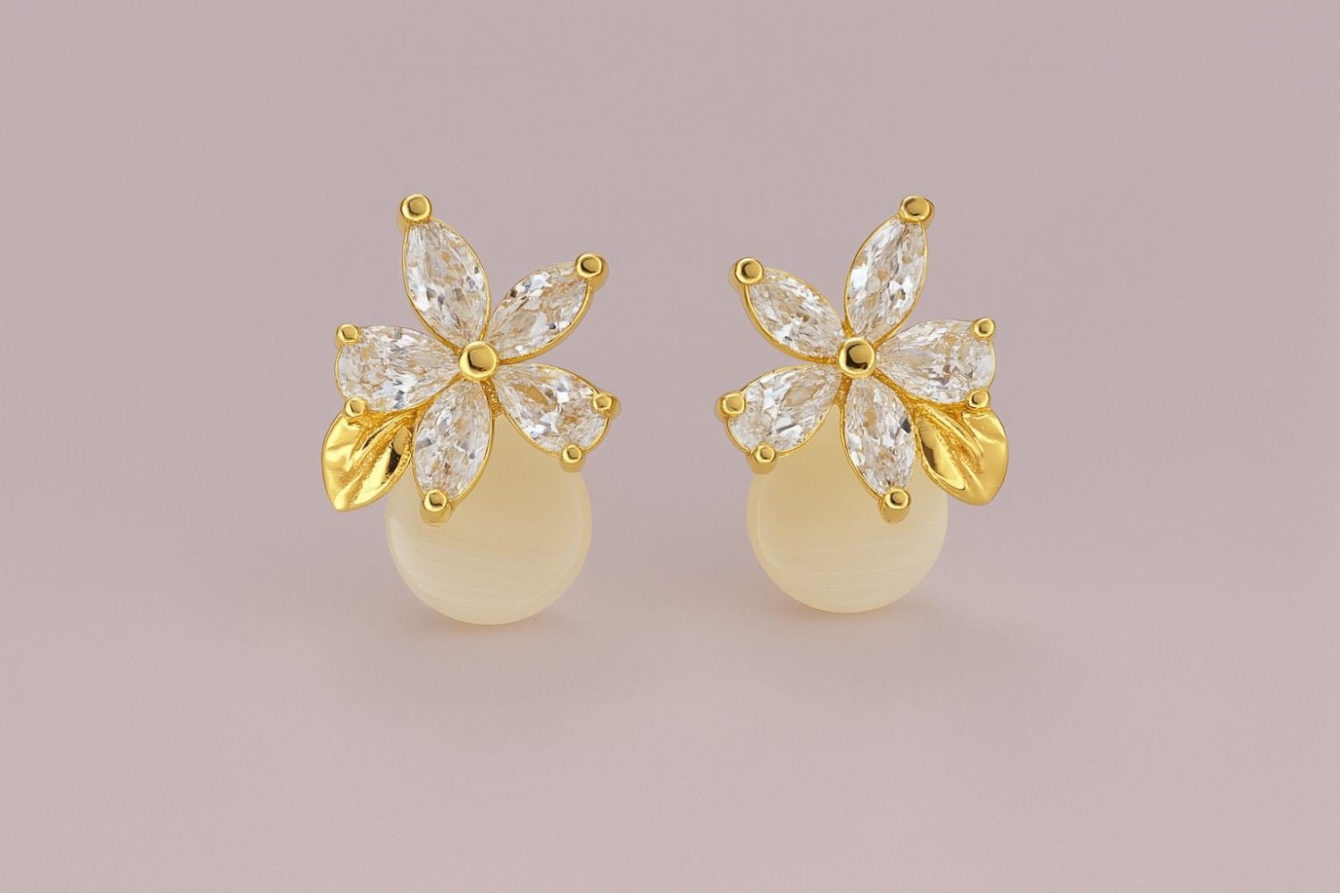 Gold-tone floral stud earrings with crystal petals and golden leaf detail on plain background
