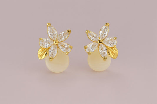 Gold-tone floral stud earrings with crystal petals and golden leaf detail on plain background