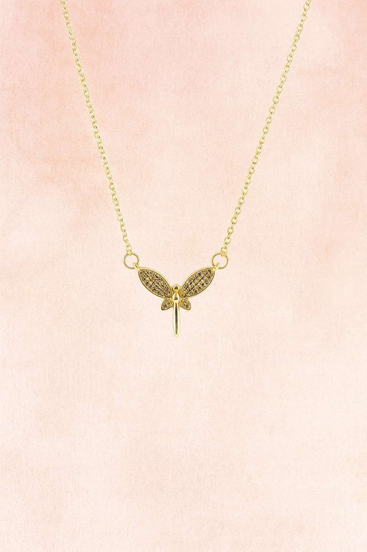Gold-tone butterfly wing pendant necklace with sparkling accents on pink background

