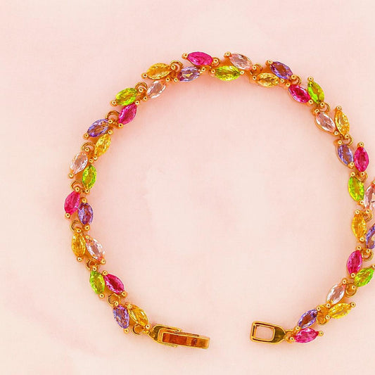 Multicolor marquise-cut crystal bracelet in gold-tone setting on pink background