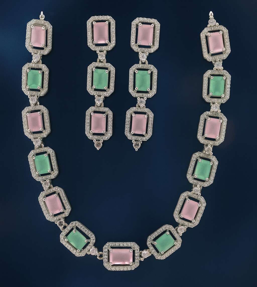 Pink and green American Diamond necklace set with earrings in silver-tone finish on dark background