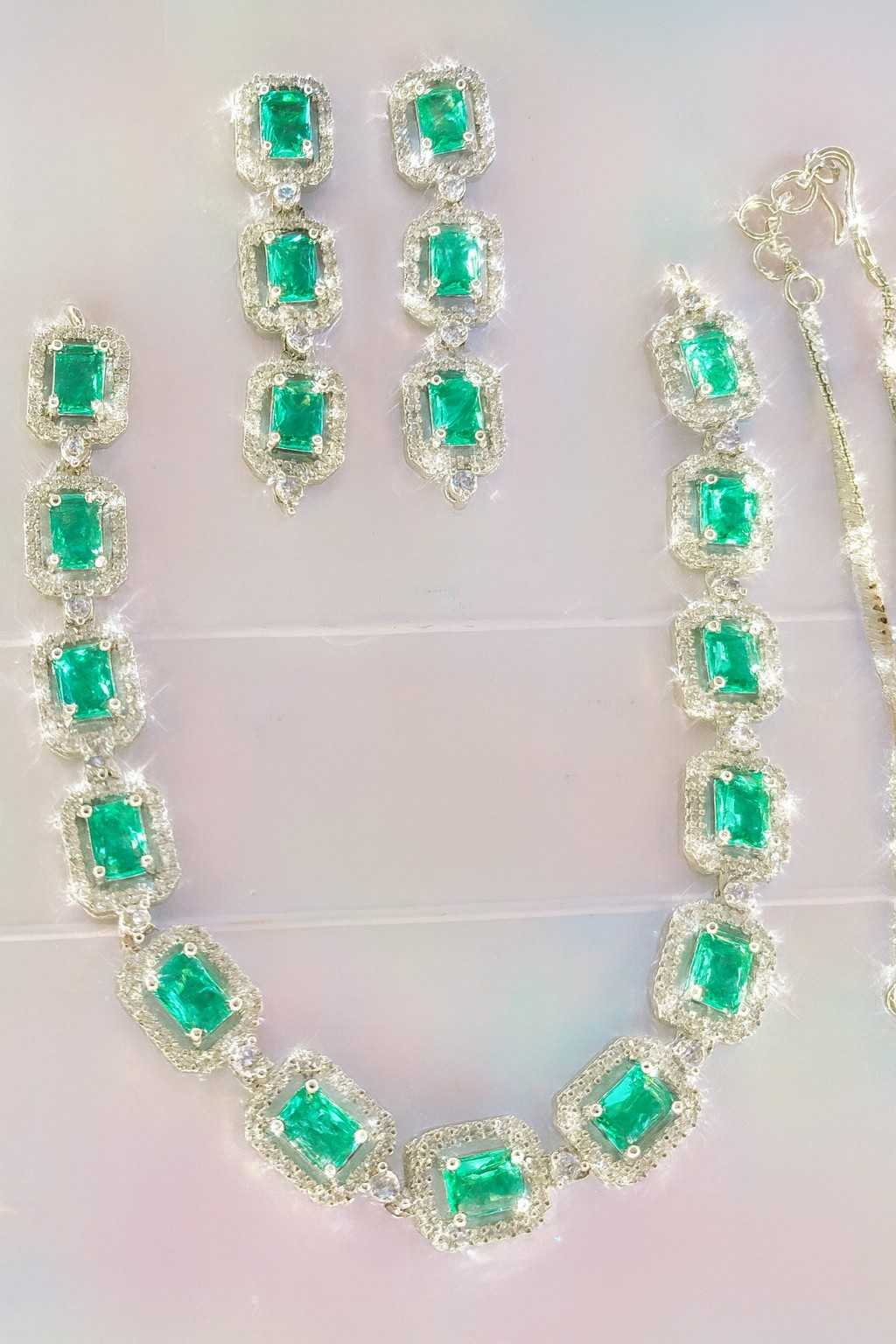 Green American Diamond necklace set with earrings in silver-tone finish on light background