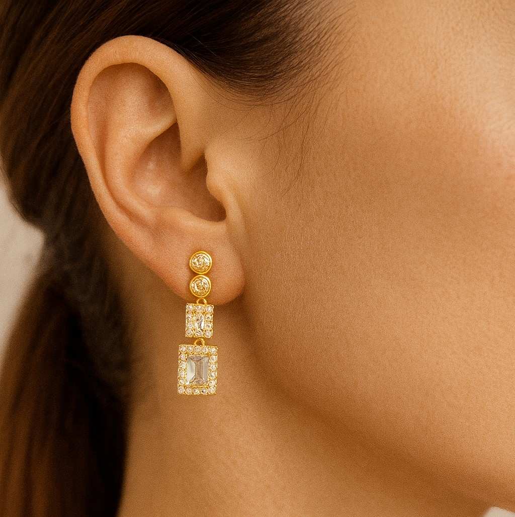 Model wearing gold-tone rectangular crystal drop earrings
