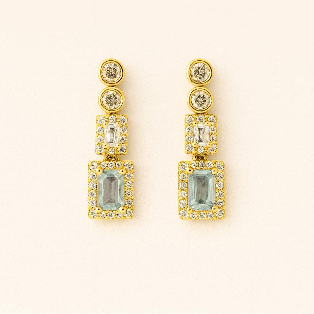 Pair of elegant gold-tone crystal drop earrings on beige background