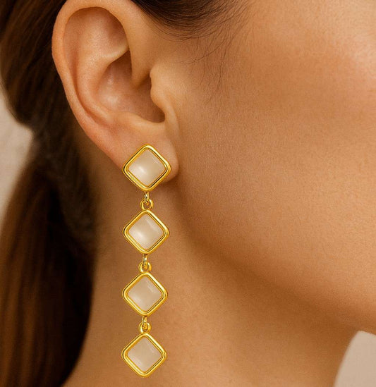 Model wearing elegant gold-tone quad square drop earrings