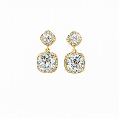 Pair of gold-tone cushion cut crystal drop earrings on white background