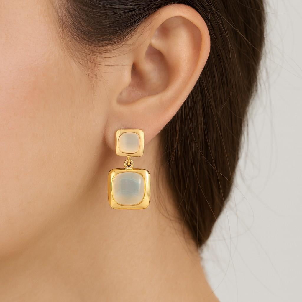 Model wearing gold-tone dual square drop earrings with icy enamel finish