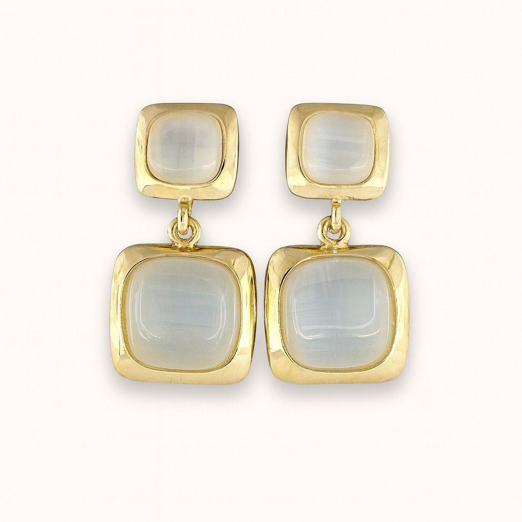 Pair of elegant gold-tone dual square drop earrings on beige background