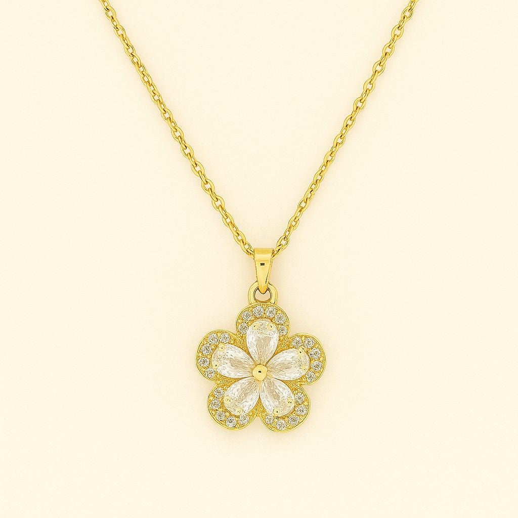 Gold-tone floral crystal pendant necklace on beige background