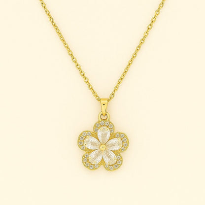 Gold-tone floral crystal pendant necklace on beige background