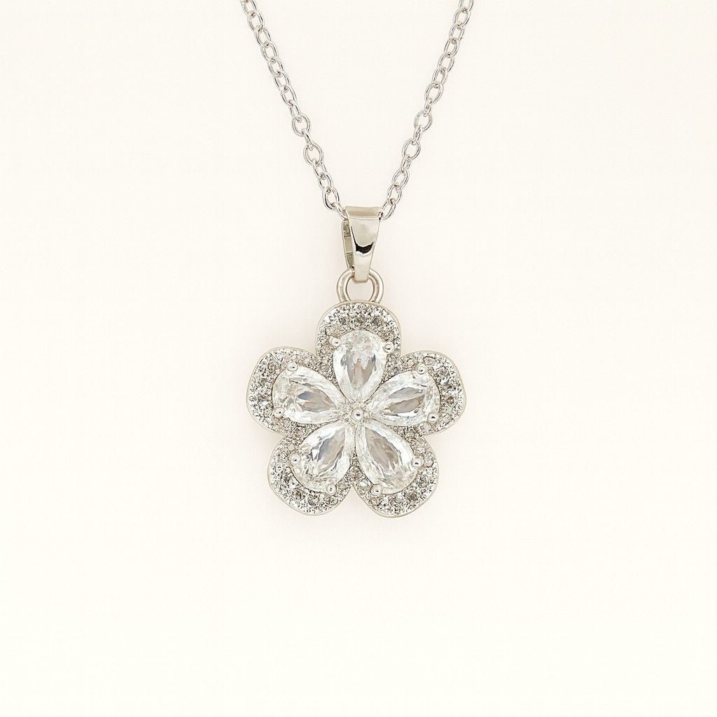 Silver-tone floral crystal pendant necklace on beige background