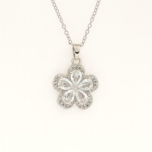 Silver-tone floral crystal pendant necklace on beige background